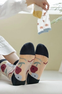 Détail de chaussettes en soie de verre transparente avec motifs cerise et pointes coton