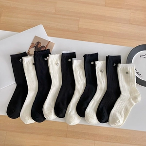 White and black frilly crew socks with cute metal charms and vertical striped patterns