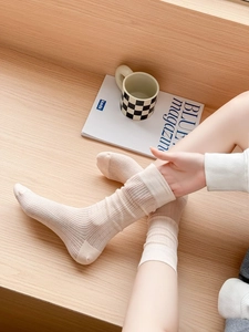 Detailed close-up of beige mesh crew socks with ribbed cuffs and breathable texture