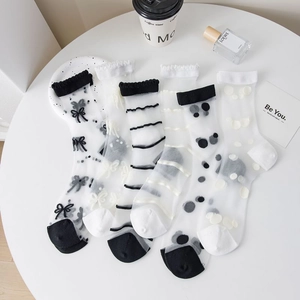 Flat lay of five sheer women's socks with varied patterns in a minimalist nordic display