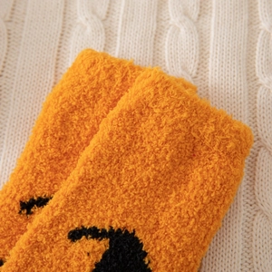 Gros plan de chaussettes moelleuses en polaire corail orange à texture douce