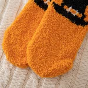 Gros plan de chaussettes en molleton corail orange avec texture jacquard noire