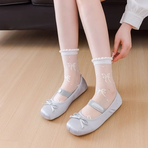 Sheer white lace socks with bow patterns paired with blue Mary Jane flats for women
