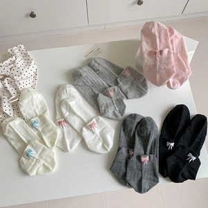 Detail of mesh socks with embroidered bow accents and hollow floral patterns in various colors
