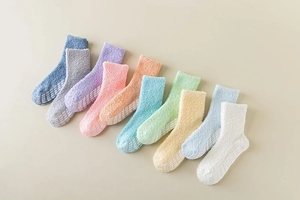 Flat lay of colorful fuzzy coral fleece socks featuring non-slip dotted grip soles