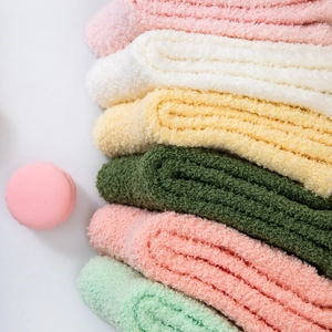 Close-up of assorted pastel coral fleece socks showing soft plush winter texture