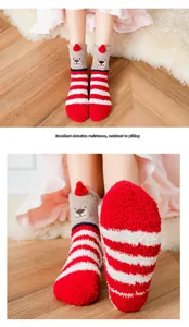 Close-up of red and white striped coral fleece socks with cute brown bear embroidery