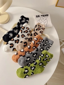 Close-up of leopard print coral fleece socks set on a cozy tray for winter warmth