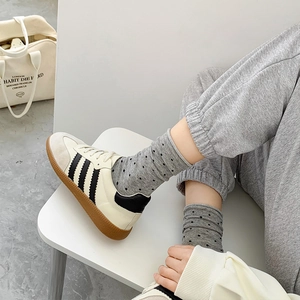 Retro cream leather sneakers with black stripes and brown rubber sole on polka dot socks