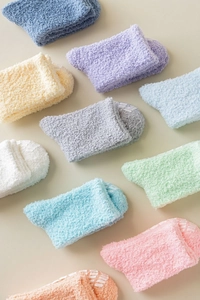 Close-up of colorful fuzzy coral fleece socks with non-slip silicone dots on soles