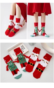 Close-up of magnetic hand-holding Christmas socks with 3D Santa and tree designs