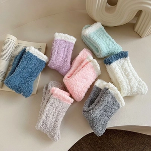 Close-up of thick coral fleece warm socks in various pastel colors with soft white trim