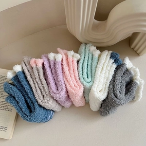 Close-up of colorful coral fleece thermal socks with fluffy texture and white wavy edges