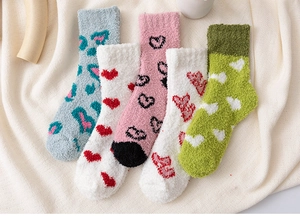 Détail de cinq paires de chaussettes d'hiver en polaire corail aux motifs de cœur et de léopard