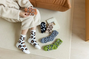 Close-up of fluffy leopard print coral fleece socks in various warm colors for winter