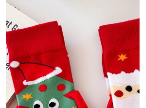 Detail of red Christmas theme knit socks with 3D holiday patterns and ribbed cuffs