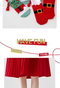 Detail of Christmas themed cartoon socks and red pleated skirt for holiday outfits
