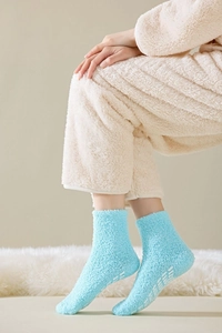 Detailed view of light blue coral fleece fuzzy socks with white anti-slip dots on the sole