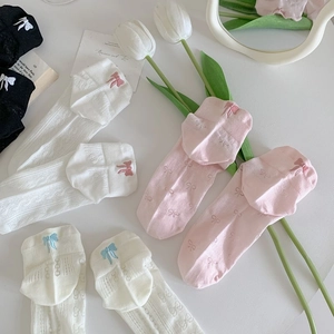 Detail of knit ankle socks featuring elegant back bow embroidery and ribbed texture