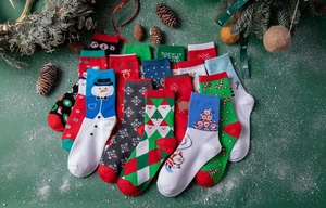 Flat lay of colorful Christmas cotton socks with festive patterns and winter decorations