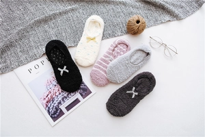 Detailed view of plush coral fleece slipper socks with anti-slip silicone soles and bow ties