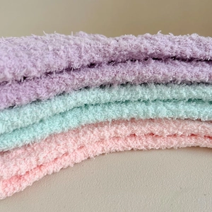 Macro view of soft coral fleece socks in pastel purple, green, and pink colors