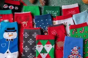 Flat lay of Christmas cotton socks with reindeer, snowman, and Santa Claus patterns