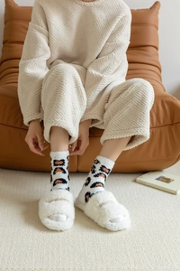 Detail of warm leopard print coral fleece socks with white plush slippers for winter comfort