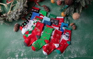 Macro detail of festive cotton Christmas socks with Santa Claus and reindeer patterns