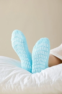 Close-up of fuzzy coral fleece thermal socks with white anti-slip grippers on the sole