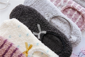 Close-up of soft coral fleece floor socks with ribbon bow and anti-slip silicone dots