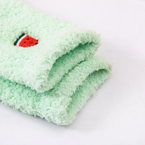 Close-up of fluffy coral fleece thermal socks featuring cute watermelon embroidery
