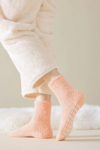 Detail of pink coral fleece thermal socks with non-slip grippers on fluffy material