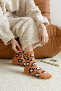 Close-up of leopard print coral fleece socks showing thick warm plush texture for winter