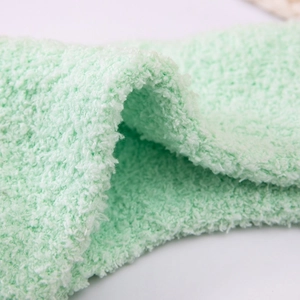 Close-up of mint green coral fleece socks showing soft fluffy texture and thick material