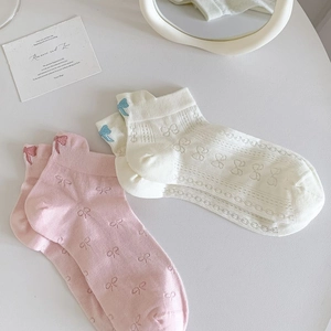 Close-up of pink and beige low-cut socks featuring bow jacquard and hollow-out mesh design