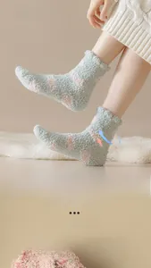Close-up of soft green thermal coral fleece socks with pink polka dots and ribbed cuffs