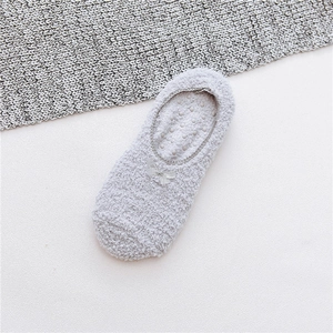 Detailed view of light gray plush floor socks with bow decoration and anti-slip silicone dots