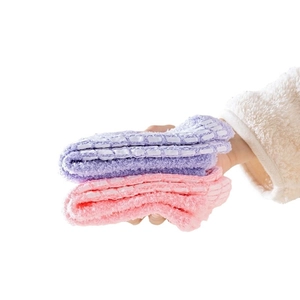 Pair of thick fuzzy socks in pink and purple with anti-slip silicone dots on the sole