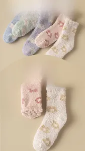 Close-up of thick coral fleece winter socks with soft flower patterns and warm texture