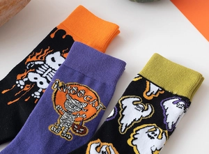 Dettaglio di calze lavorate a maglia per Halloween con motivi di scheletro mummia e fantasma