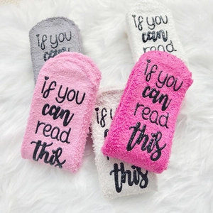 Detail of soft fuzzy socks featuring if you can read this text on plush coral fleece