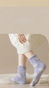 Close-up of light purple coral fleece socks with small floral patterns and wavy cuffs