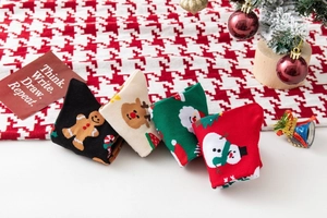 Detailed view of four festive Christmas socks featuring Gingerbread man, Elk, Santa, and Snowman