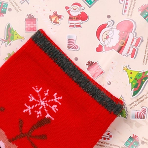 Close-up of red Christmas socks with knitted snowflake patterns and reindeer details