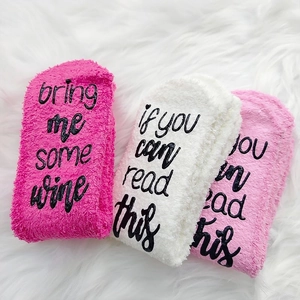 Detail of coral fleece fuzzy socks with anti-slip wine slogan lettering on soles