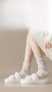 Detailed close-up of thick coral fleece socks paired with plush cross-strap house slippers