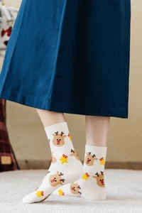 Detail of white cotton Christmas socks featuring cartoon reindeer and bell patterns