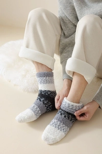 Gros plan de chaussettes d'hiver épaisses en polaire corail à rayures grises et noires