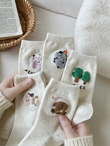 Dettaglio ravvicinato di calze in cotone morbido con ricami cartoon e pois colorati